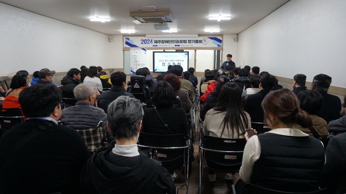 정기총회 장면. 많은사람들이 강당에 모여있으며, 화면을 보며 김성환 부장이 설명하고 있다.